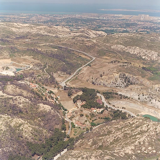 Vue du hameau de la Nerthe, du chemin de la Nerthe avec les lacs dans les anciennes carrières. Au loin, l'étang de Berre. Vue aérienne prise du sud.