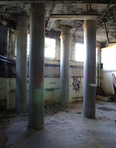 Vue prise de l'ouest, quatre piliers de soutènement d'une partie du plancher, bâtiment d'angle.