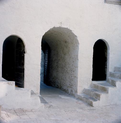 Donjon (1) : débouché de la porte sur la cour intérieure, escaliers de la galerie d'étage.