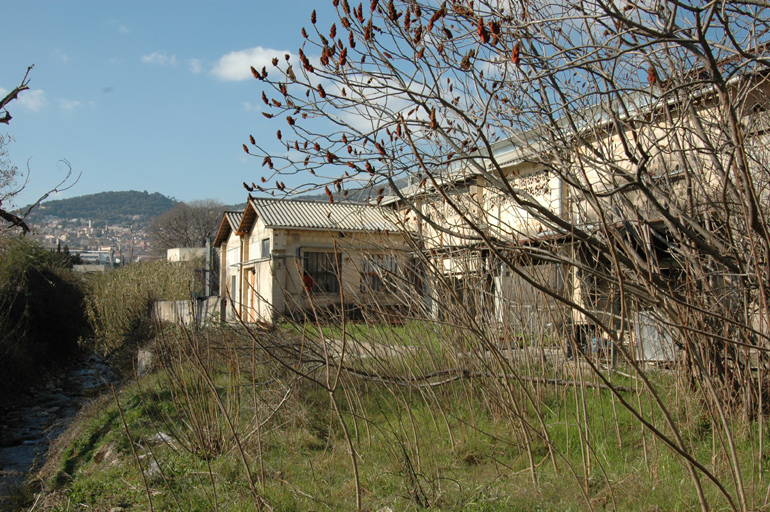 Vue de l'arrière du premier bâtiment, situé à proximité d'un cours d'eau.