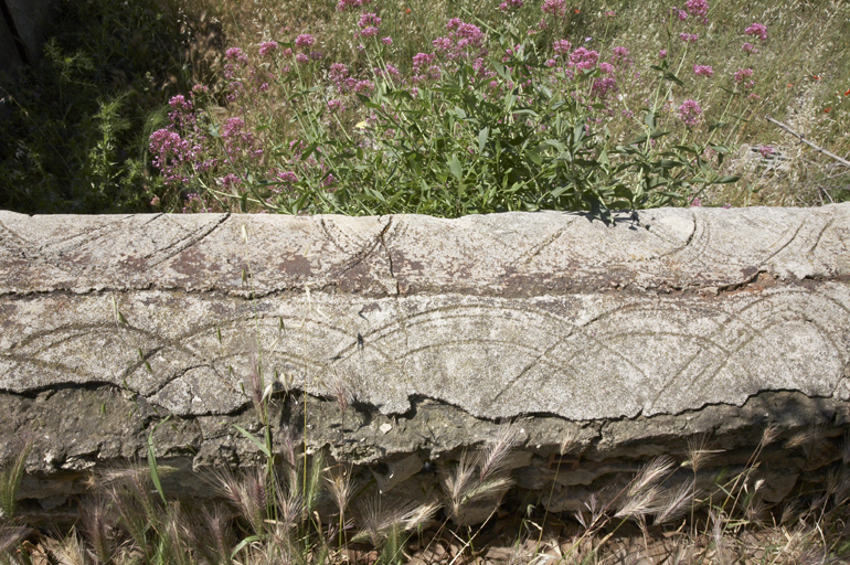 Mur de clôture de l'ensemble du jardinier : rebord avec dessin dans le ciment.