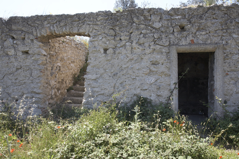 Jardin au nord-est du logis. Allée avec mur de soutènement avec escalier de jardin et entrée d'une grotte de fraîcheur.