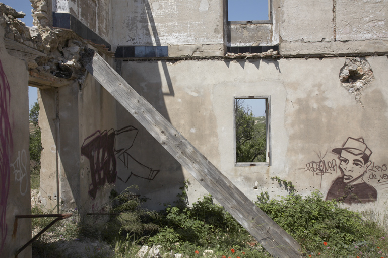 Bâtiment d'exploitation : extrémité ouest. Intérieur. Détail : matériaux et graffiti.