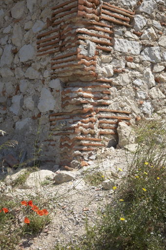 Extrémité du bâtiment d'exploitation, élévation ouest : détail des matériaux. Chaîne d'angle en tuiles, murs en appareil mixte calcaire et terre cuite.