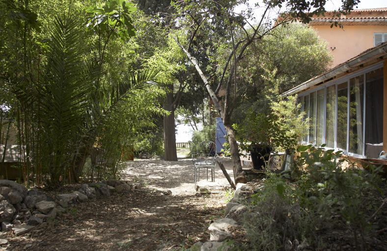 Véranda et allée de jardin : au fond la grande terrasse devant la maison.