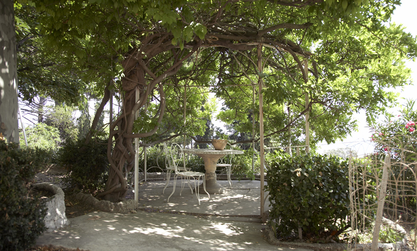 Coin de jardin aménagé avec kiosque et bordures de plate-bande en rocaille.