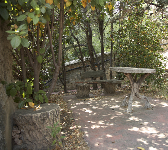 Jardin. Extrémité nord de la terrasse : table et sièges en rocaille.