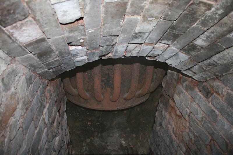 Détail du bas de la cuve de chauffe vu à travers le conduit de chargement du combustible.
