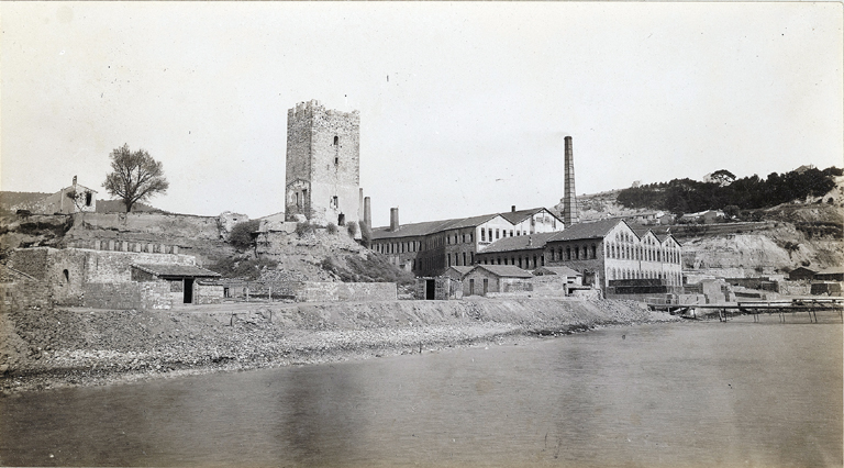 Tour Saumati. [Vers 1900 : De part et d'autre de la tour, au premier plan aire de séchage et vestiges des constructions, à gauche la grande tuilerie des frères Roux avec les embarcadères.]