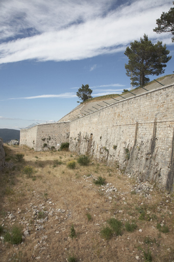 Enceinte : front de gorge ouest, vu du sud, courtine (1-2),  bastion nord-ouest (1), fossé, vu du pont d'accès.