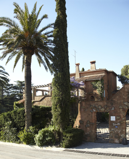 Vue d'ensemble du portail et de la villa prise de l'avenue.