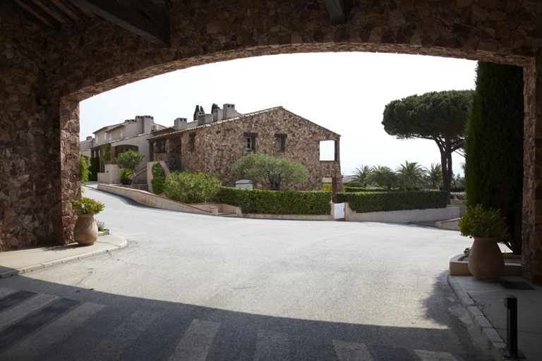 Porche d'entrée et îlot de maisons de l'ensemble résidentiel de vacances El Cantarello. Meinier. 6, chemin rural dit de la Vierge Noire.