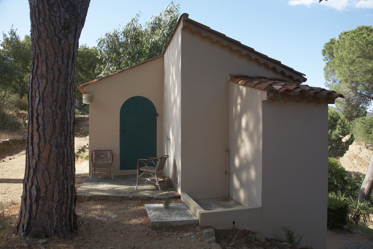 Bâtiment abritant l'atelier en rez-de-chaussée surélevé au-dessus d'une chambre. Façade sud. Une douche est aménagée à l'extérieur.