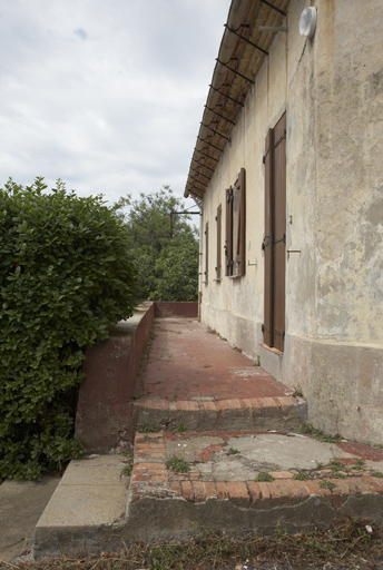 Rez-de-chaussée surélevé. Passage longeant le bâtiment sur trois de ses côtés.