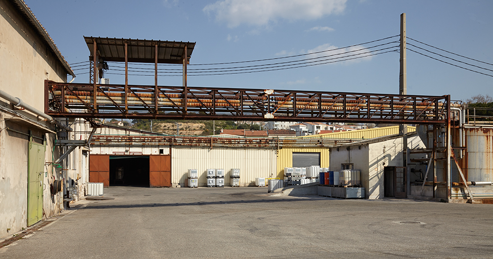 Cuve et conduites d'acheminement des huiles. Au loin les bâtiments de stockage des détergents.