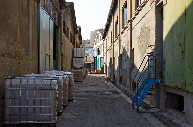 Une rue de l'usine. A gauche un bâtiment de stockage, à droite celui des chaudrons.