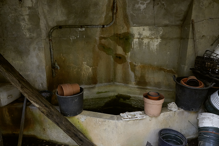 Point d'eau dans la serre muni d'une cuve en béton armé de plan losangique.