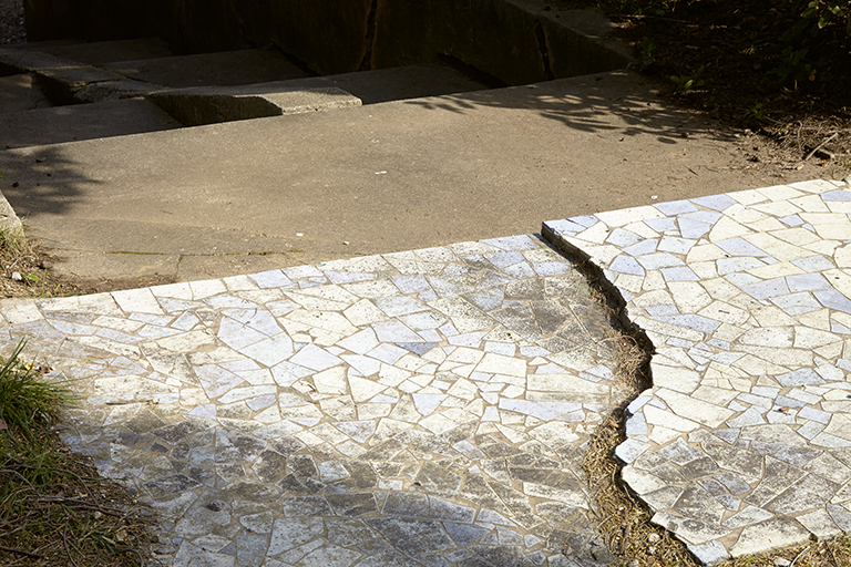 Jardin. Palier d'un escalier revêtu de tesselles bleues et blanches.