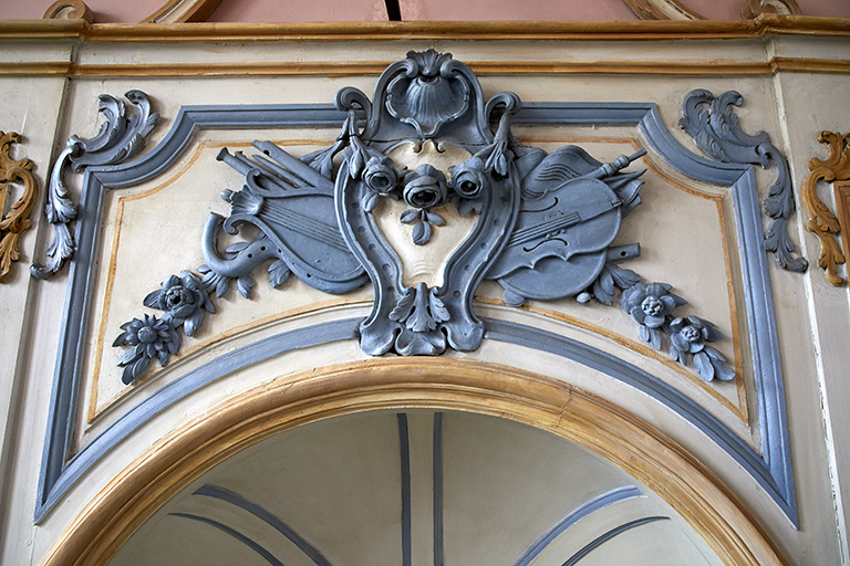 Couronnement du siège de l'officiant : cartouche avec instruments de musique (après restauration).