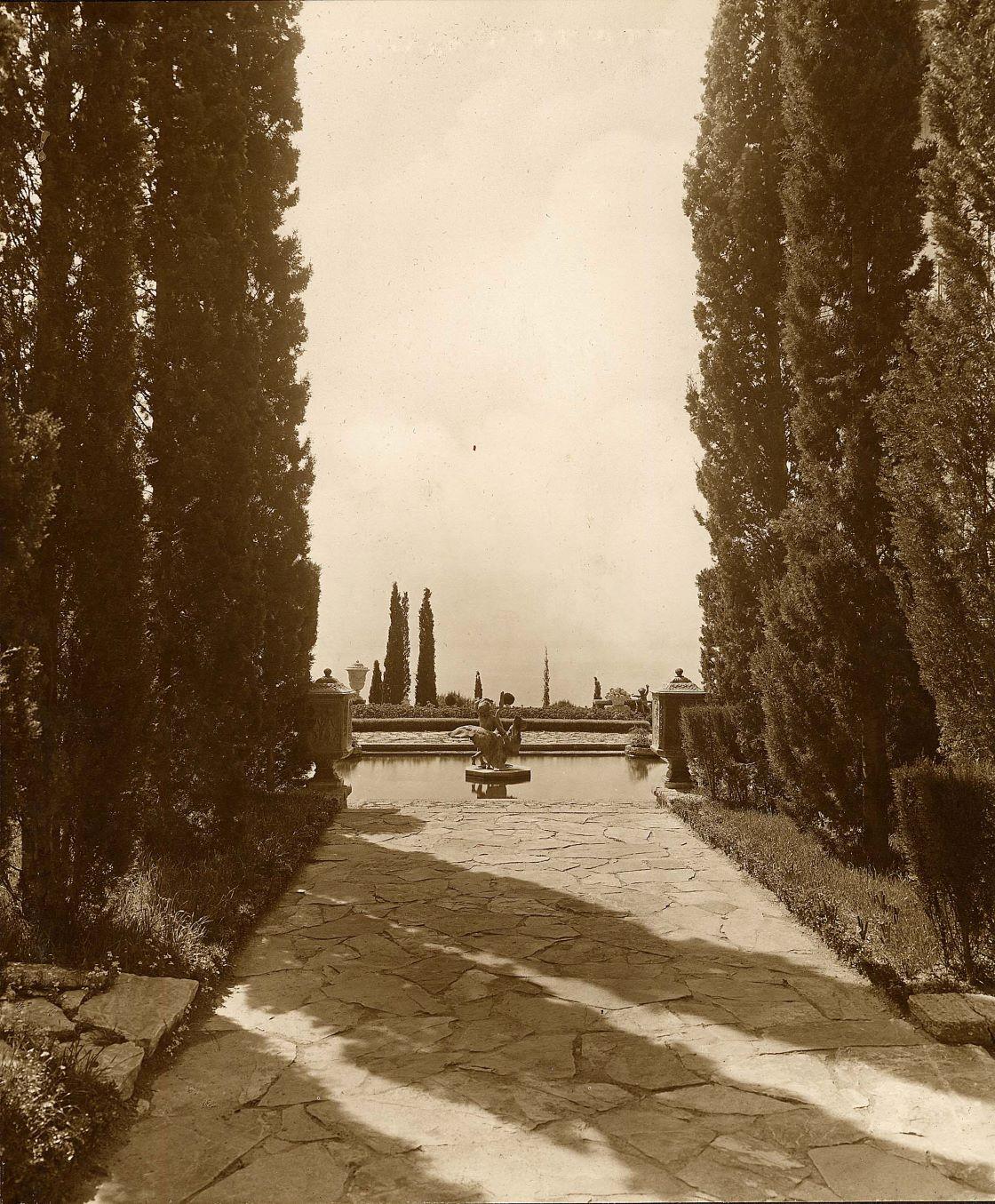 [Château de la Croix des Gardes à Cannes. Vue de l'allée de cyprès en direction de l'impluvium à l'est du château, 2e état avec groupe sculpté au centre du bassin.], [années 1940 ?].