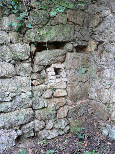 Vue d'ensemble d'une porte murée en rez-de-chaussée.