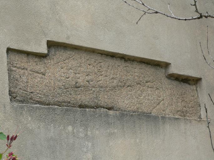 Vue d'ensemble du linteau de l'ancienne église, utilisé en remploi dans le mur du chevet.