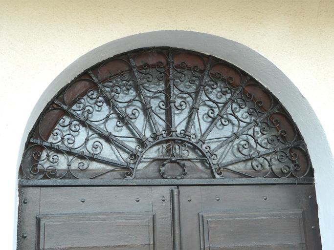 Vue d'ensemble de l'imposte en fer forgé de la porte d'entrée.