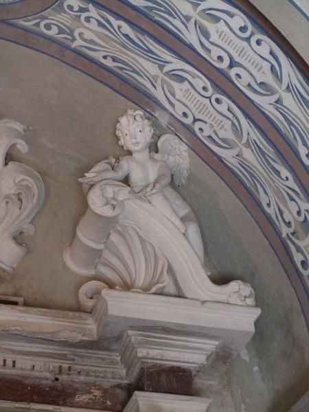 Angelot, en appui sur les rampants du fronton.