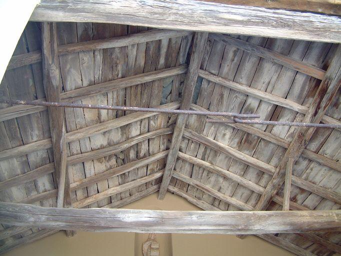 Vue d'ensemble de la charpente en bois apparente du porche.