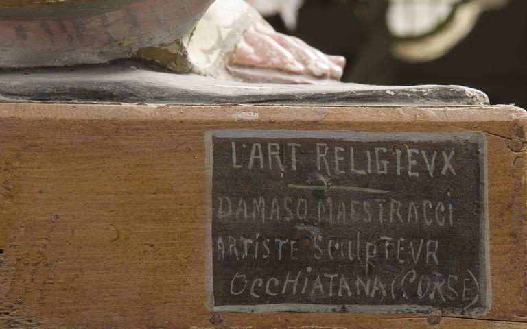 Vue d'ensemble de la signature portée sur le socle de la statue de sainte Lucie.