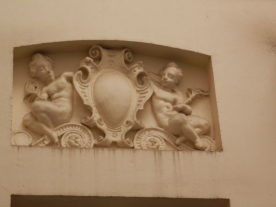 façade sur cour, détail d’un haut-relief : Putti encadrant un blason