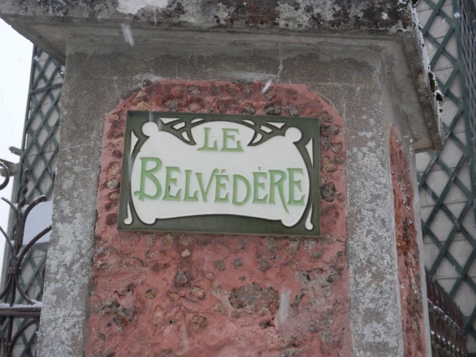 pilier encadrant le portail d’entrée, détail de la plaque avec le nom de la maison