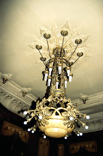 Grand salon, rez-de-chaussée : lustre en bronze ciselé avec coupe en albâtre et branches d'hortensias en bronze, assurant l'éclairage électrique indirect ; au plafond, rosace en stuc ornée de guirlandes de roses. - (c) Monuments historiques, ADAGP, 1996