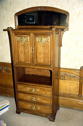 Chambre de monsieur et madame Bouctot, premier étage : meuble en bois sculpté, à motifs de branches et pommes-de-pin et appliques en bronze ciselé à motif floral. - (c) Monuments historiques, ADAGP, 1996