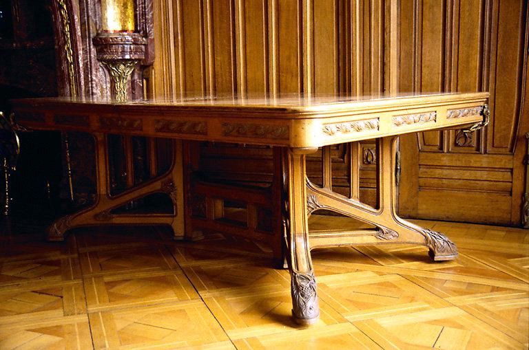 Salle à manger, rez-de-chaussée : table en bois sculpté, à motifs de branches et de pommes-de-pin. - (c) Monuments historiques, ADAGP, 1996