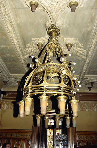 Salle à manger, rez-de-chaussée : lustre en bronze ciselé, avec motifs de roses de noël, de branches et de pommes-de-pin, et luminaires en pâte de verre. - (c) Monuments historiques, ADAGP, 1996