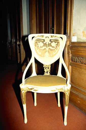 Palier, premier étage : chaise en bois sculpté, peint et doré, à motif floral. - (c) Monuments historiques, ADAGP, 1996