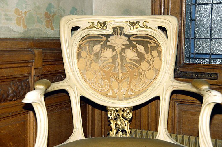 Palier, premier étage : dossier de fauteuil en bois sculpté, peint et doré, à motif floral. - (c) Monuments historiques, ADAGP, 1996