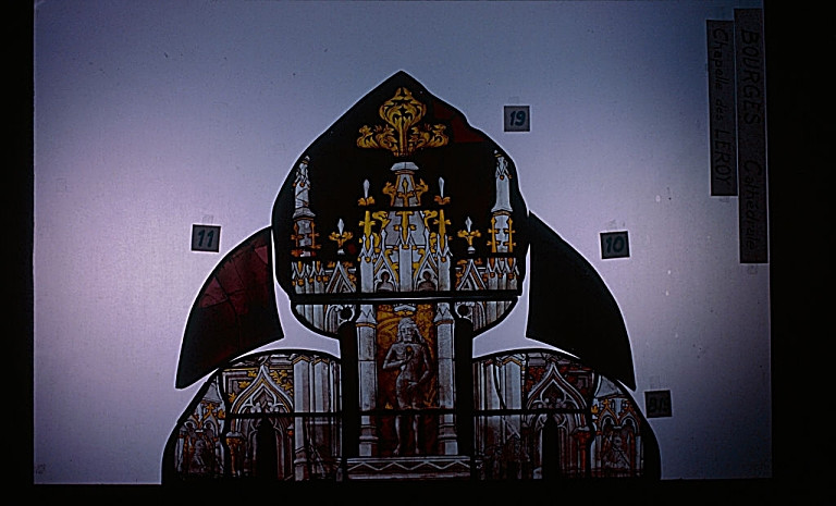 Verrière de la chapelle de Jean Le Roy (baie 44) : Quatre lancettes et tympan à vingt et un ajours (Après restauration) : deux ajours ; le haut de la deuxième lancette, dans le pinacle une statuette de Adam.