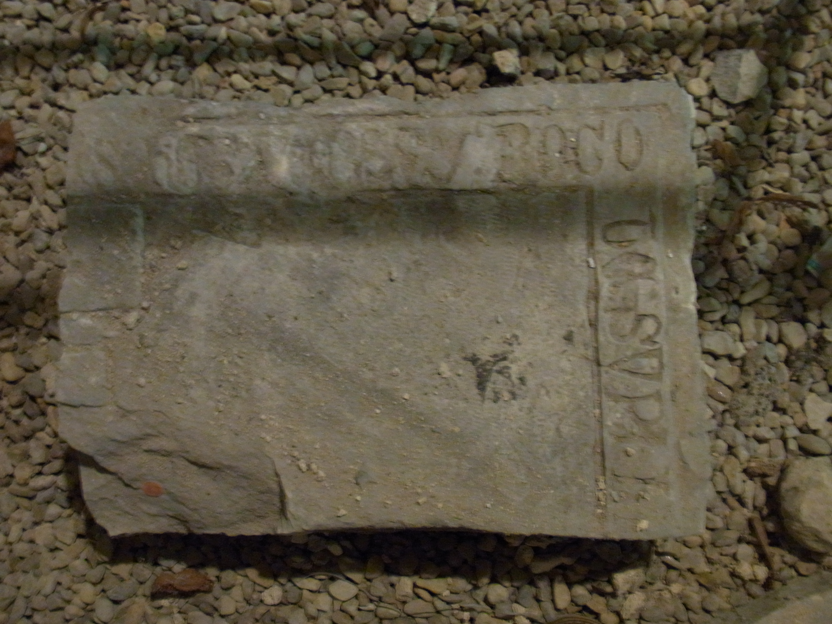 Fragment d'une plate-tombe gravée d'une inscription en majuscules gothiques