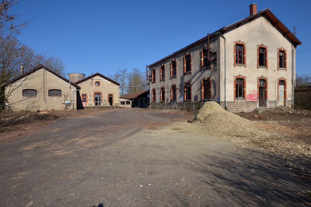 à droite, les bureaux, au centre les vestiaires, les douches et le parking à 2 roues 