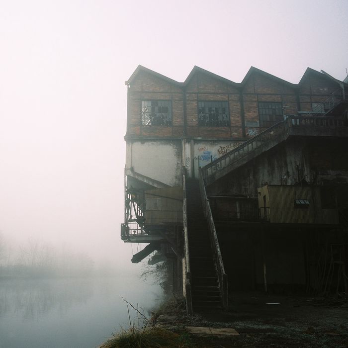 façade est et son escalier permettant d'accéder aux étages du lavoir un jour de brouillard