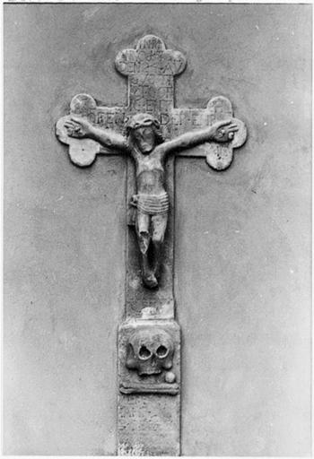 Crucifix de 1732 remployé dans le pan est du chevet.