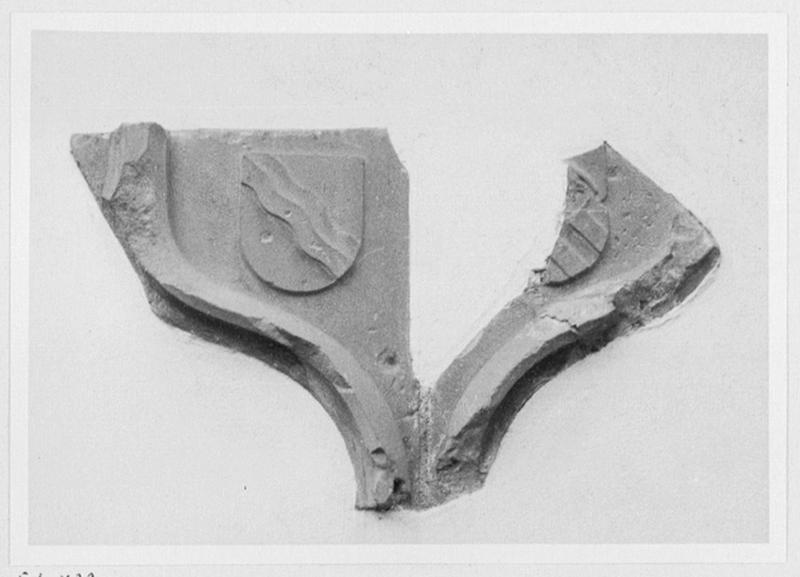 Fragment d'architecture en accolade (avec armes non identifiées) encastré dans le chevet et provenant du château détruit, vue d'ensemble.