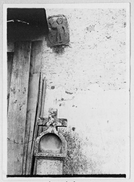 Relief médiéval de figure humaine encastré dans le mur est et croix dite bildstock (daté 1702), vue d'ensemble.