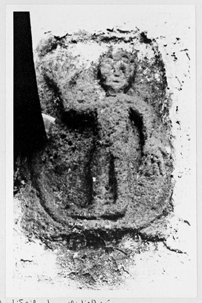 Relief médiéval de figure humaine encastré dans le mur est, vue d'ensemble.