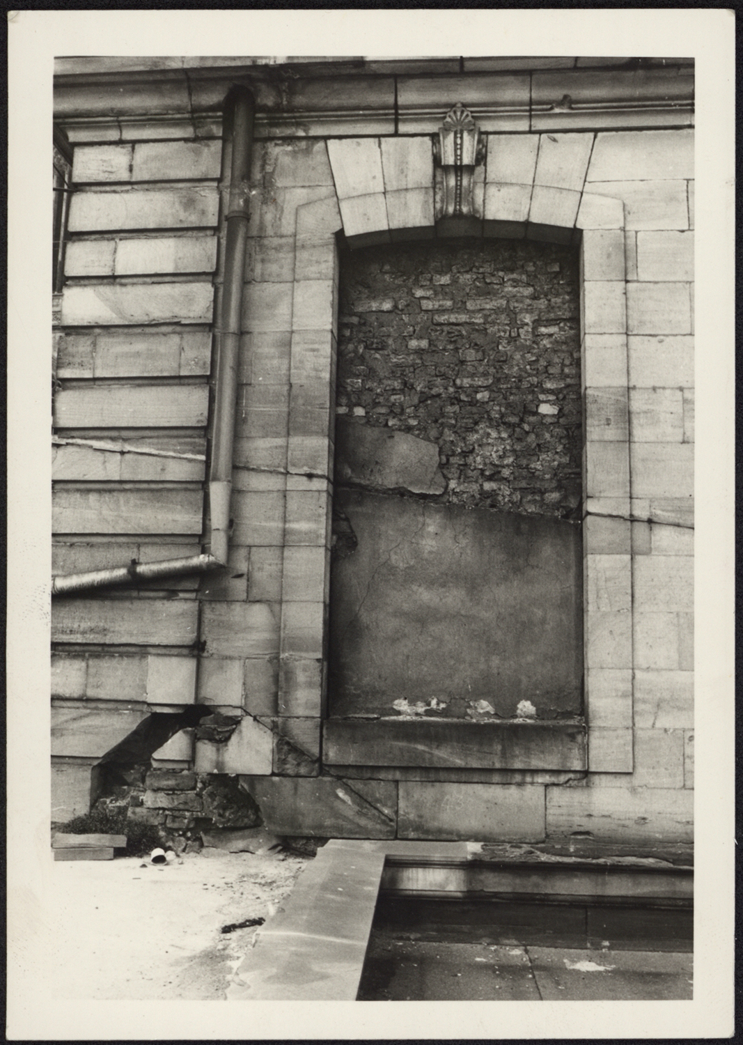 Vue de détail de claveaux disjoints et des pierres altérées de l’angle gauche du côté sud du pavillon nord-ouest.