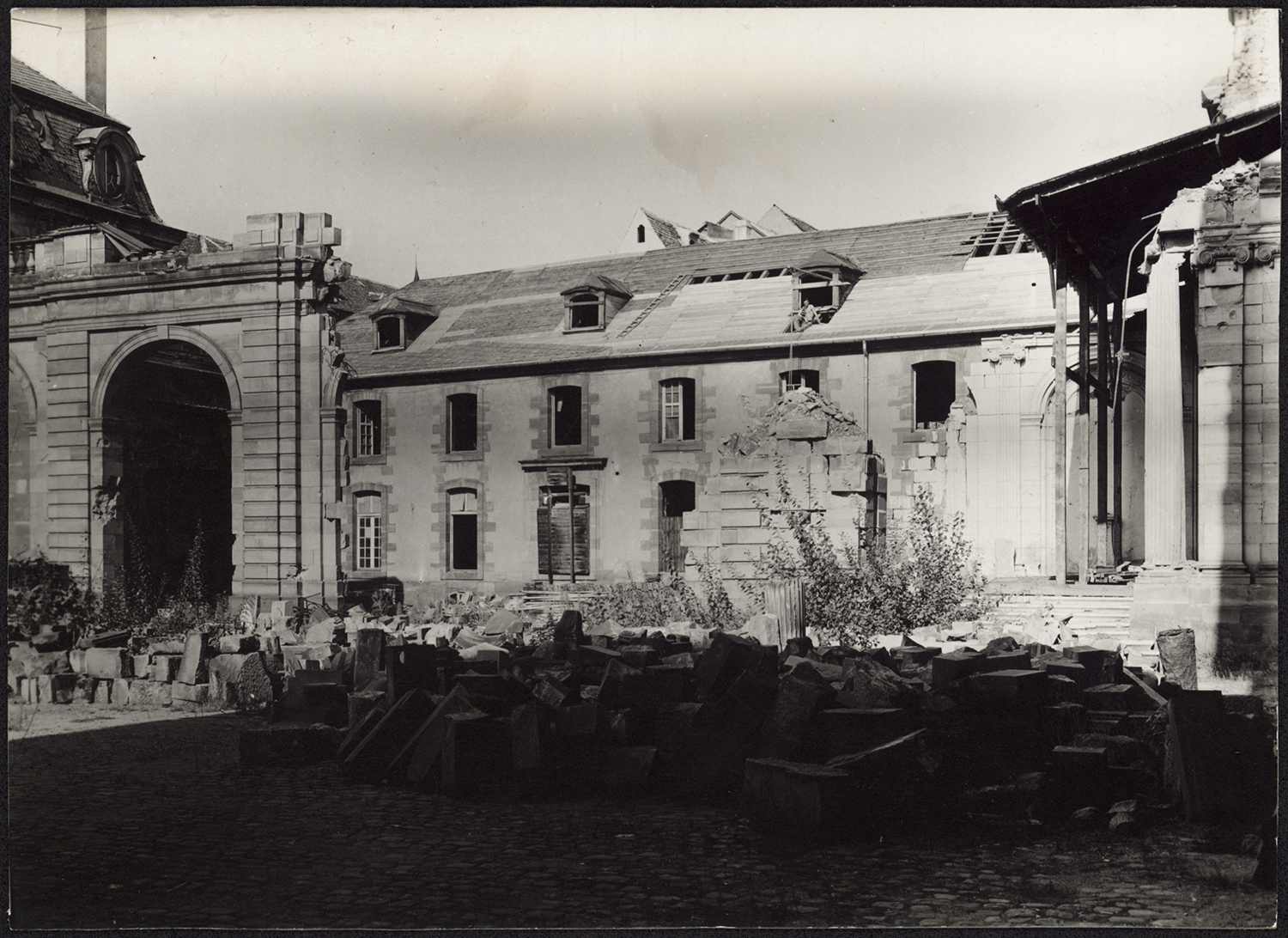 Vue d’ensemble de la couverture de l’aile est et du démantèlement du mur de séparation depuis la cour d’honneur.