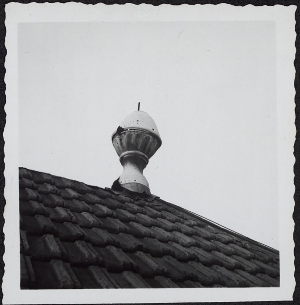 Vue de détail d'un pot à feu endommagé et de la couverture provisoire en tuiles mécaniques. 