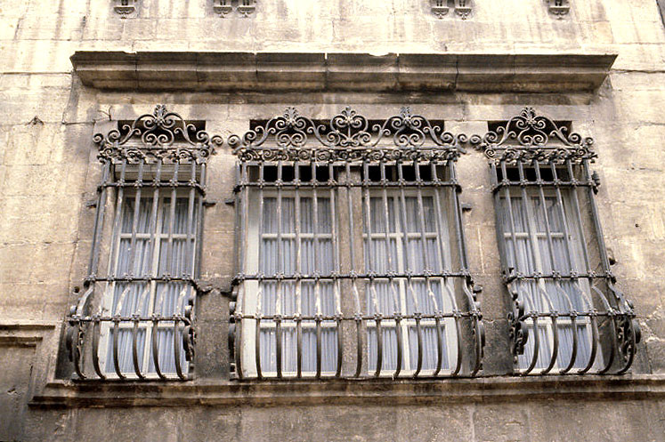 Façade antérieure sur la rue : fenêtres au rez-de-chaussée avec grille en fer forgé.